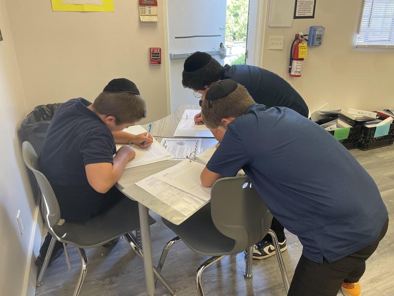 3 eighth grade boys working together.