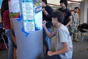 student signs  a CSUSB poster