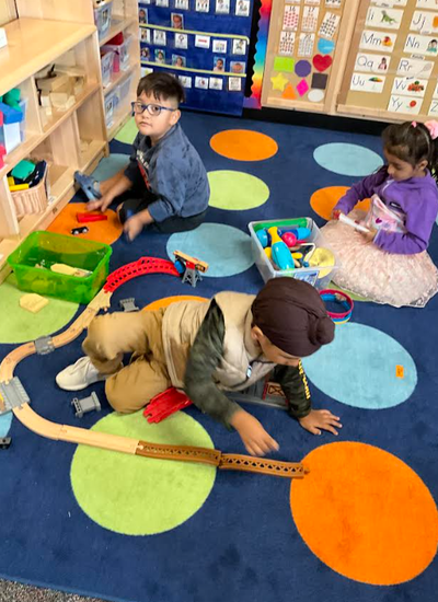 Three students playing with toys