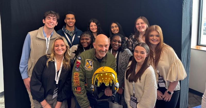 Photo of Students standing around the Blue Angel pilot