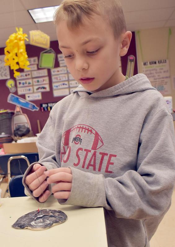A student putting tiny beads on a wire