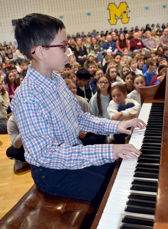 a boy playing a piano