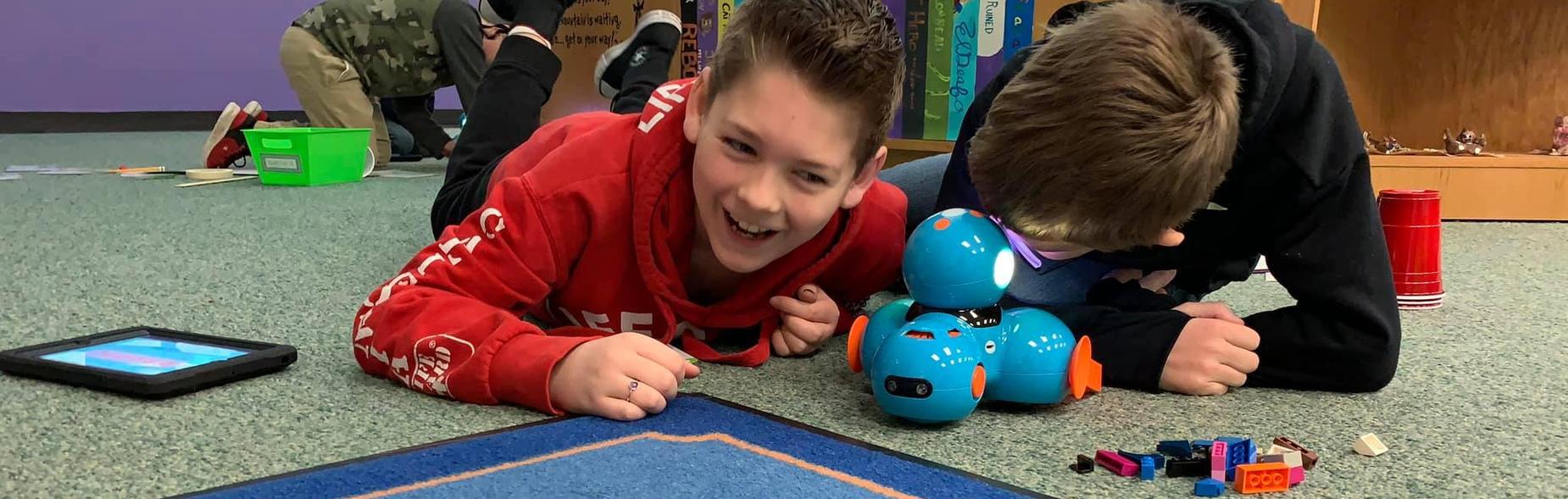 Kids listening to robots in coding class