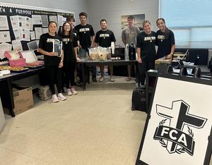 FCA students and Cage Mills in the teachers lounge with the coffee and breakfast foods