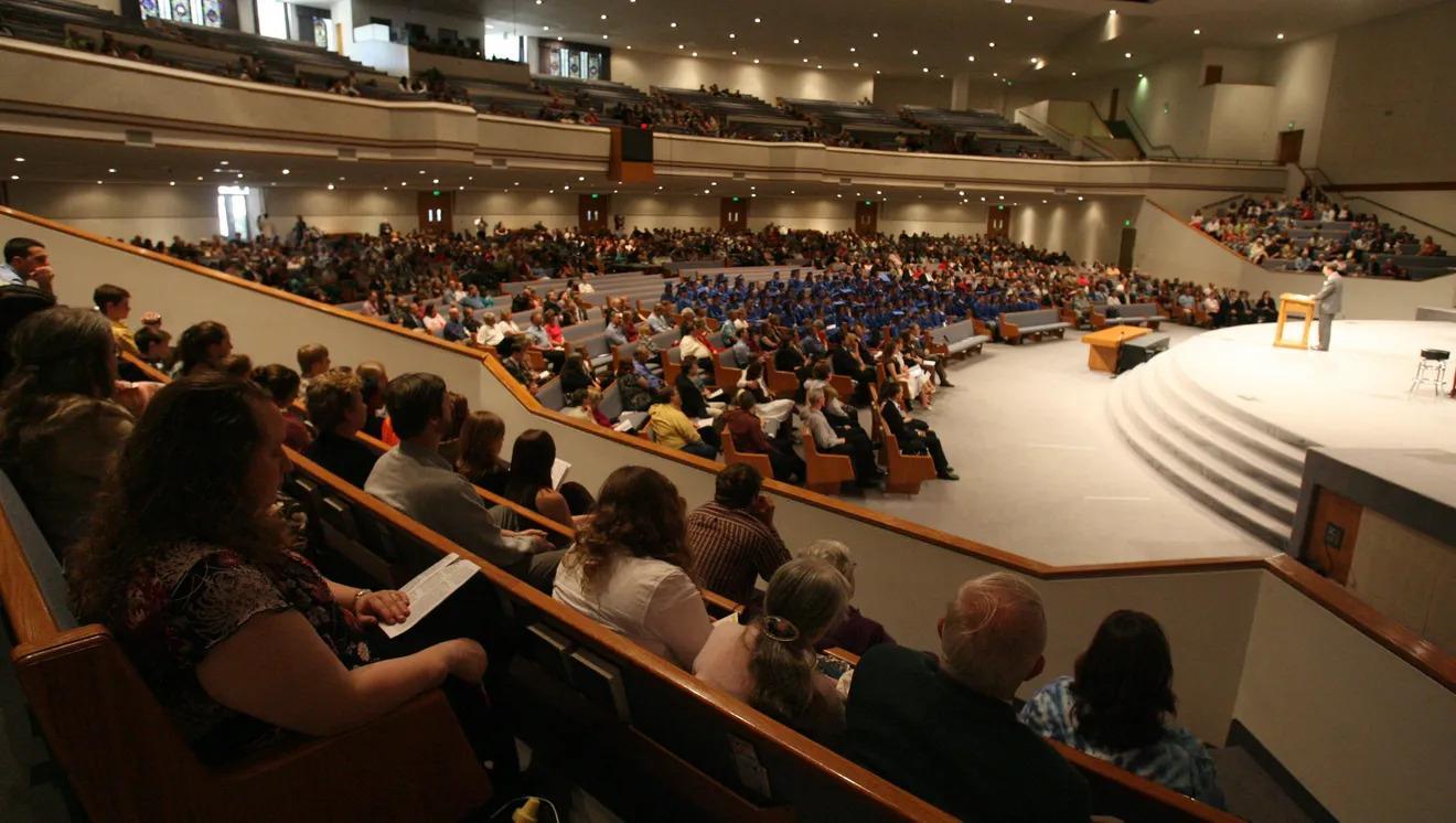 Auditorium with full audience watching a speaker on stage