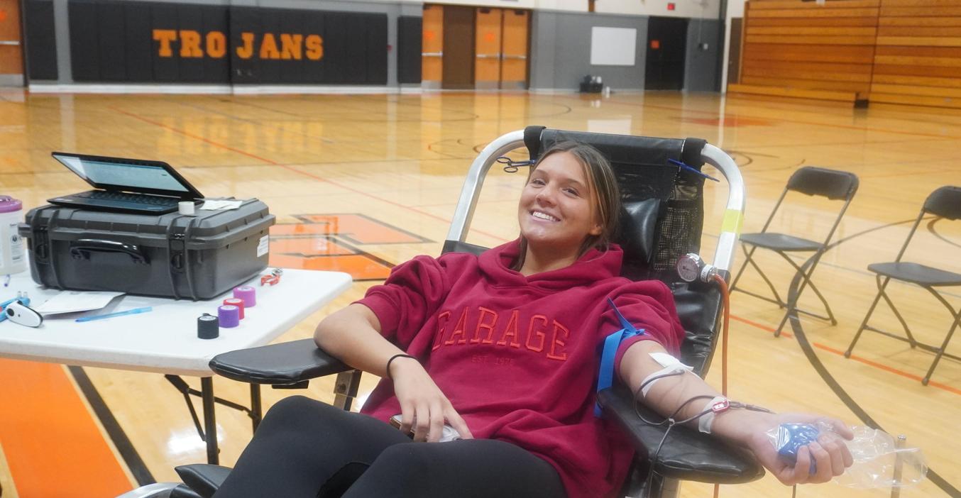A high school student donates blood at the National Honor Society blood drive.