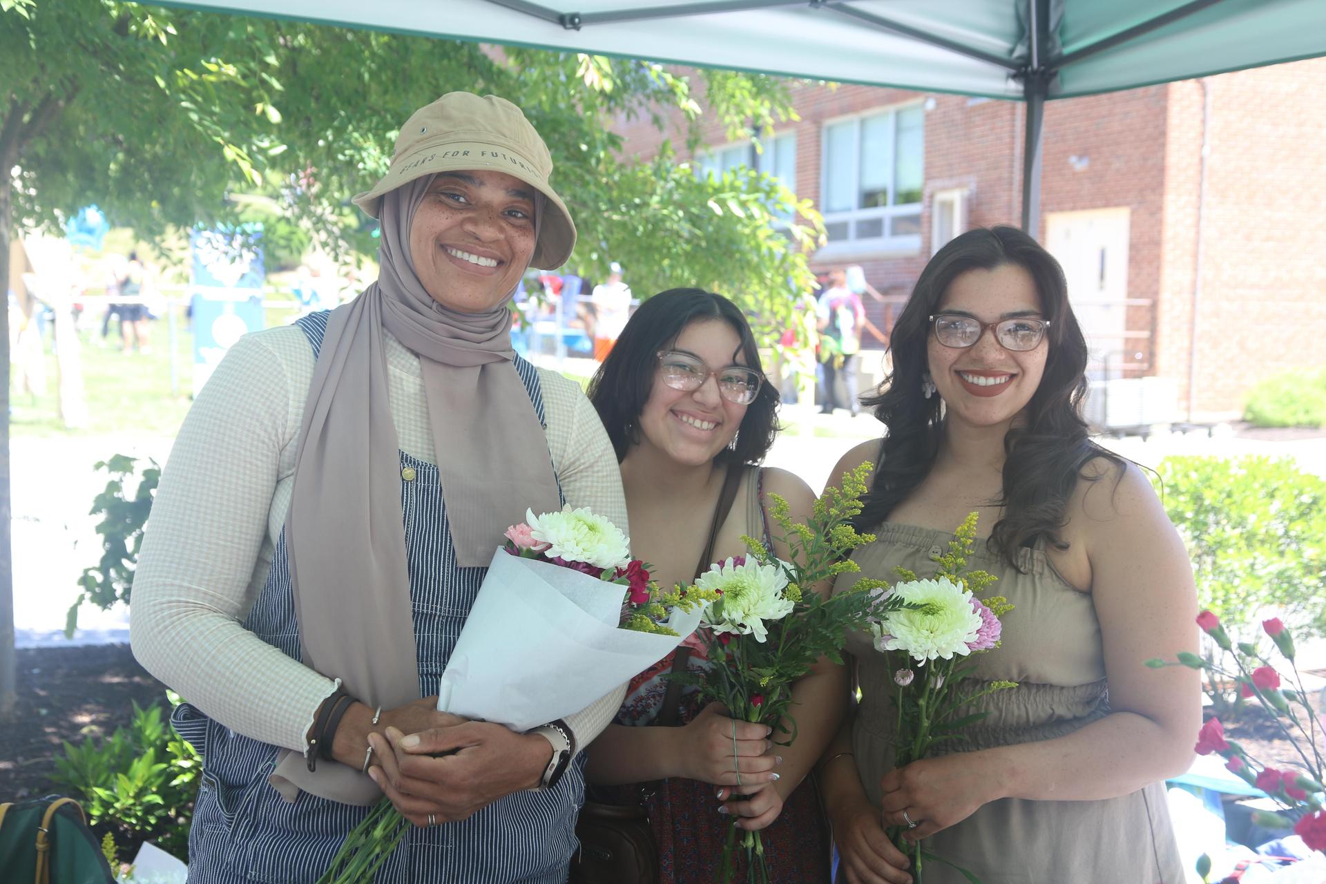 Three women holding flowers.