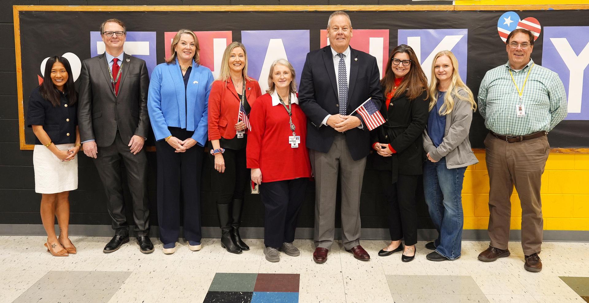 Group of educators posing for a photo with a banner saying 'Thank You.'