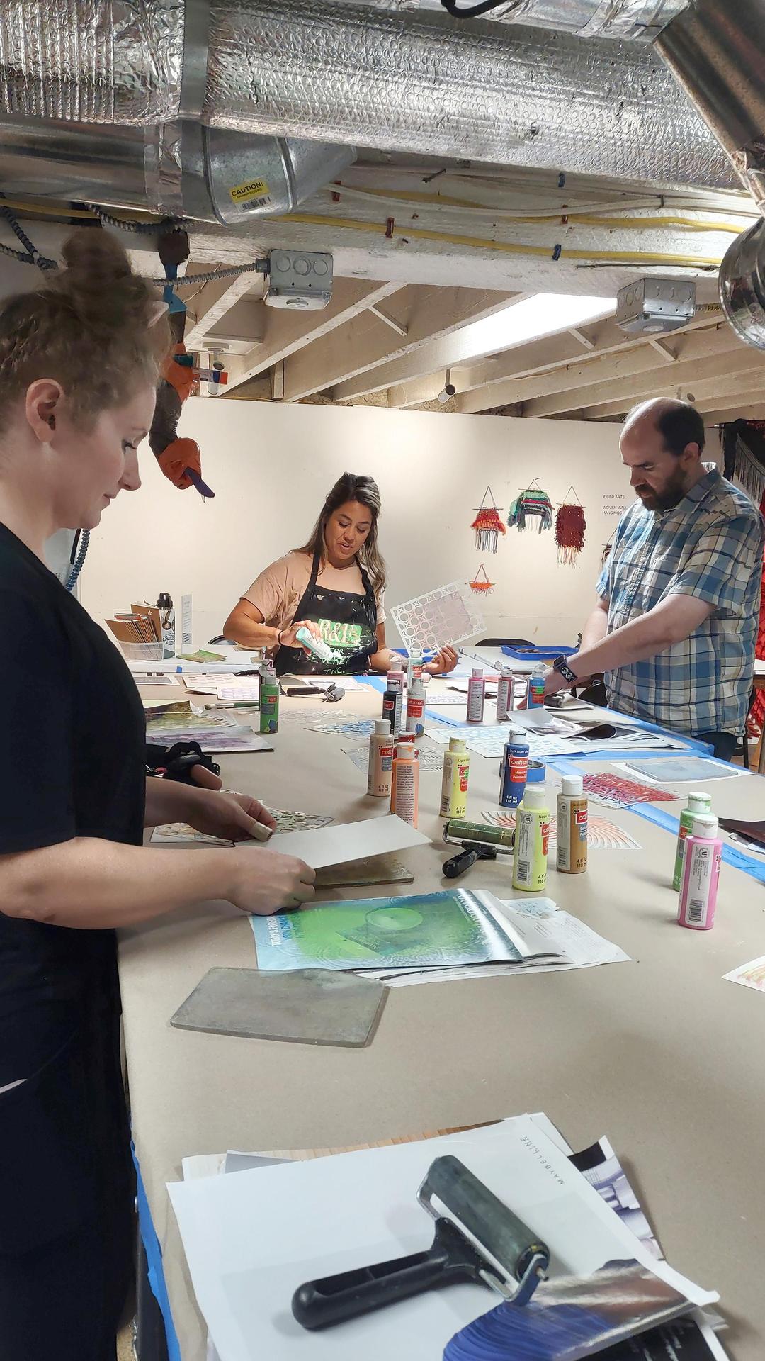 Art teachers, standing and working around a large table