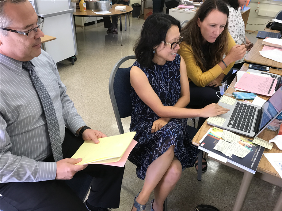 three people working on a laptop