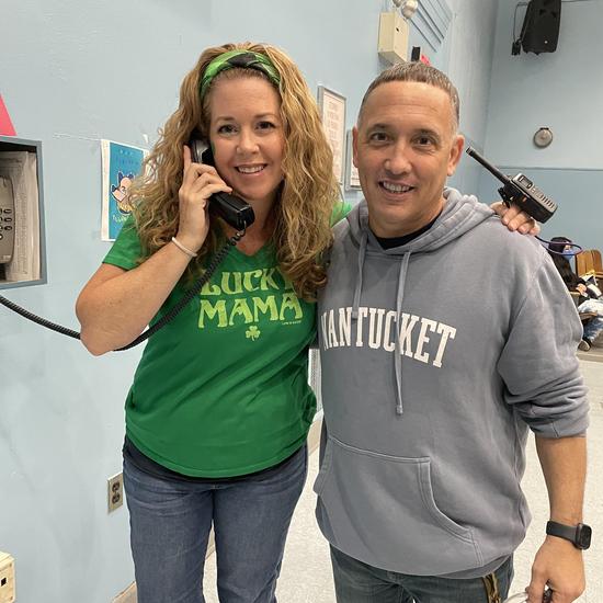 two staff members posing together, smiling