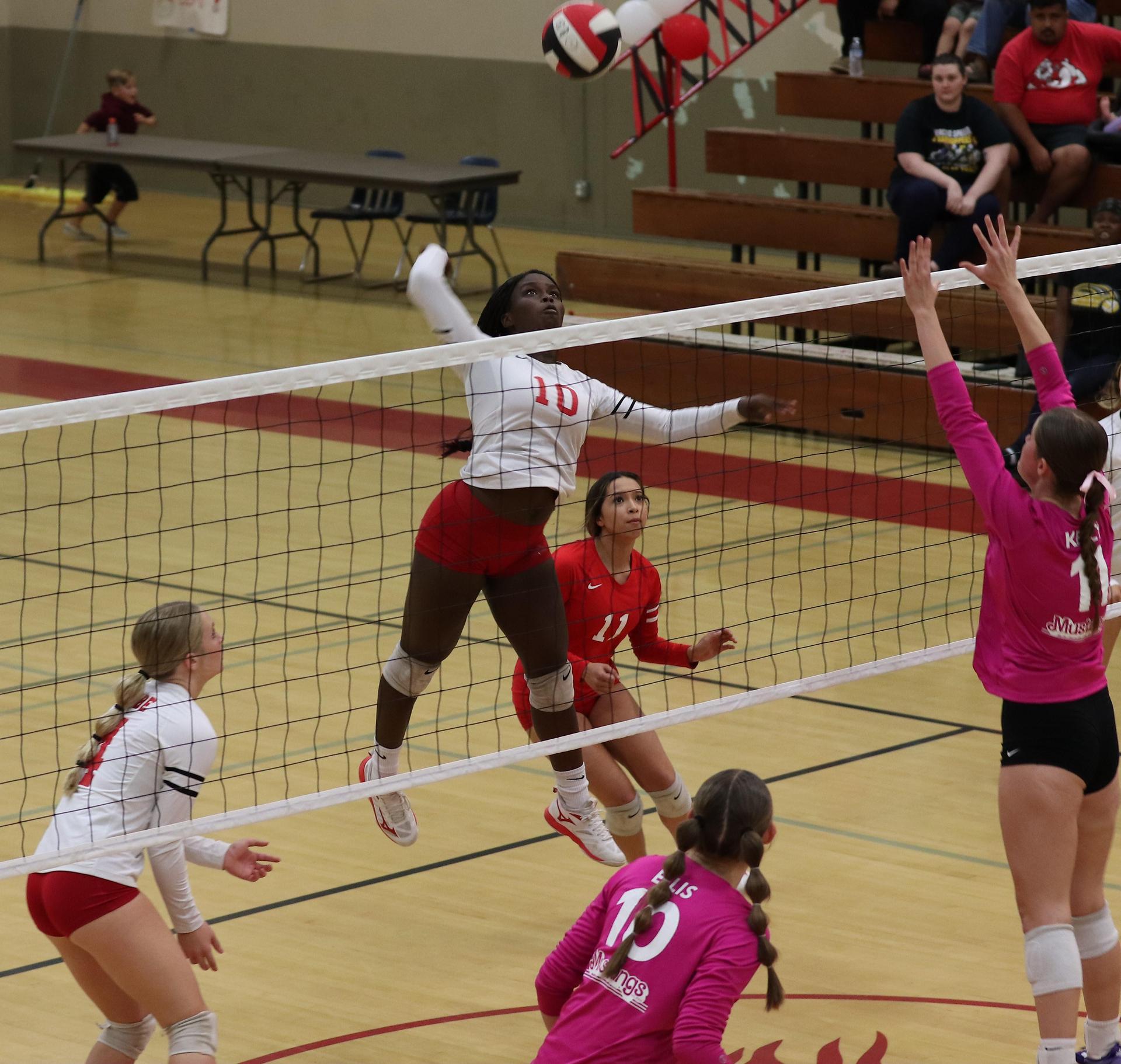 varsity volleyball players in action against Minarets