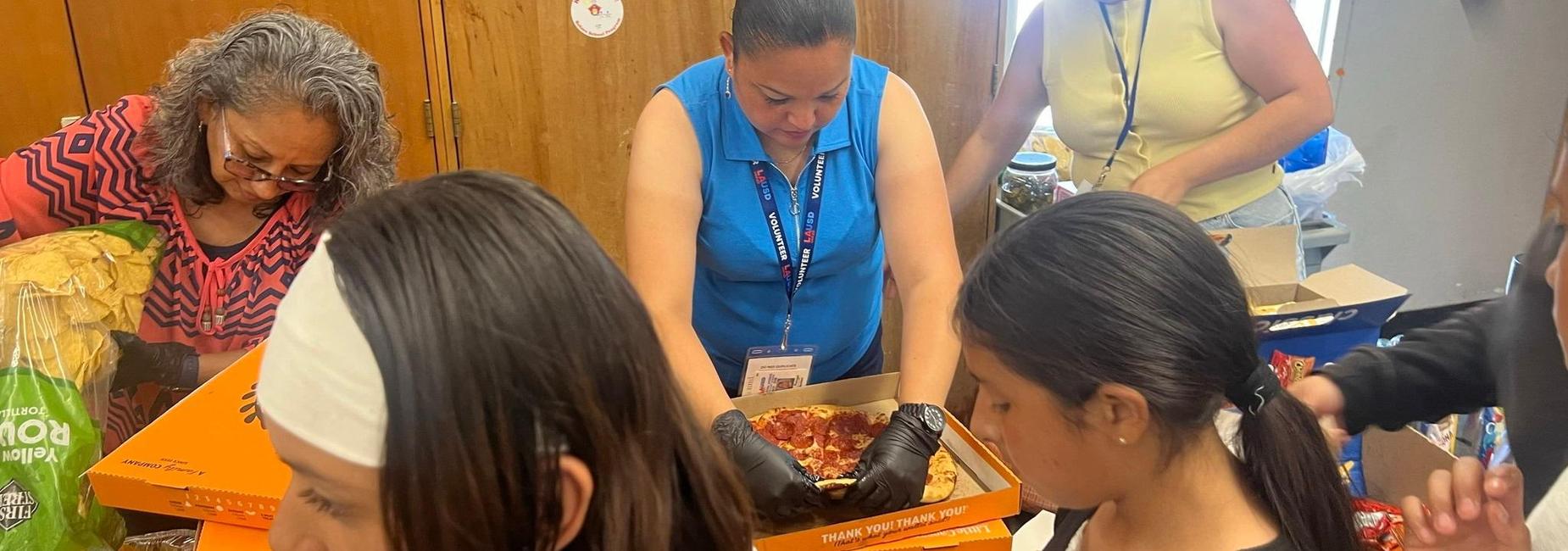 Parents serving pizza at 5th Grade Luncheon