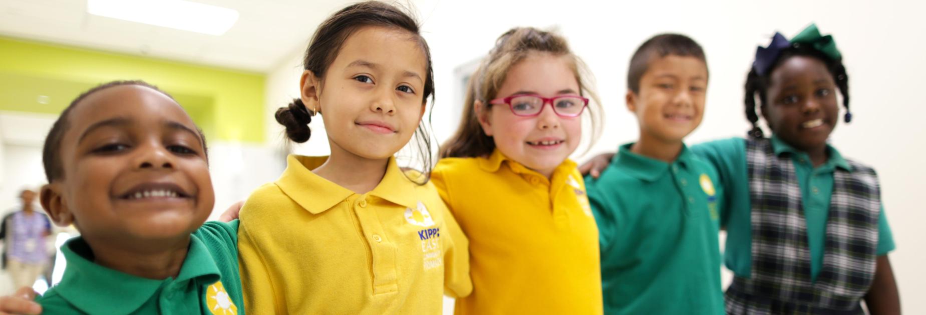 Five students from KIPP East Community Primary standing in a row smiling at the camera