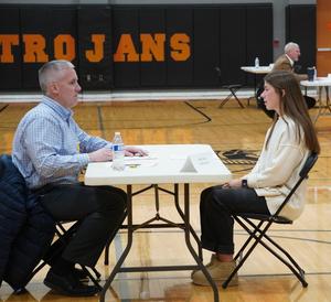 A senior girl talks with a representative of a local company.