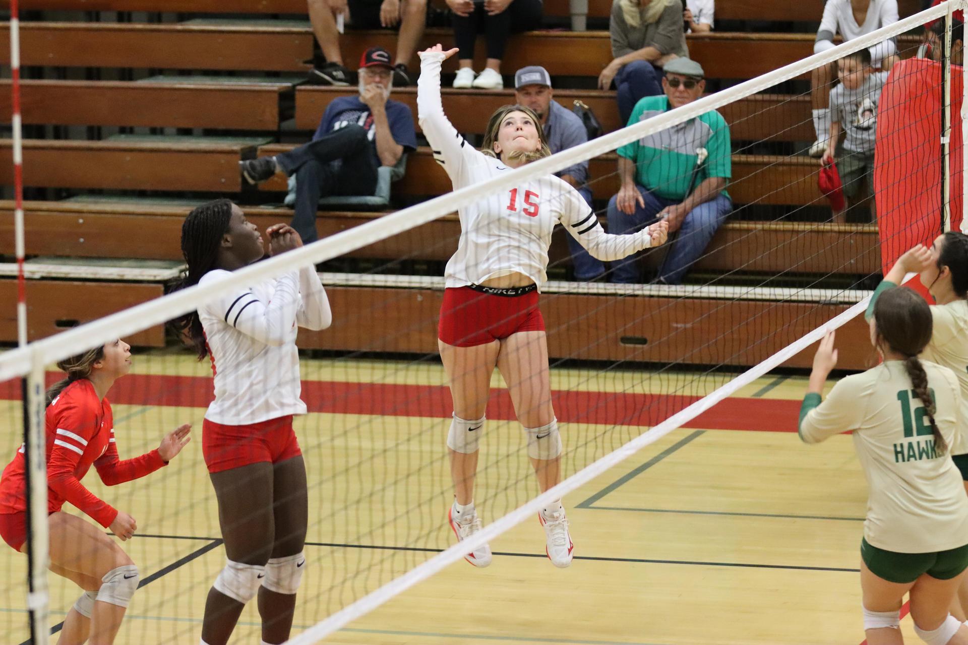 varsity volleyball players in action against liberty