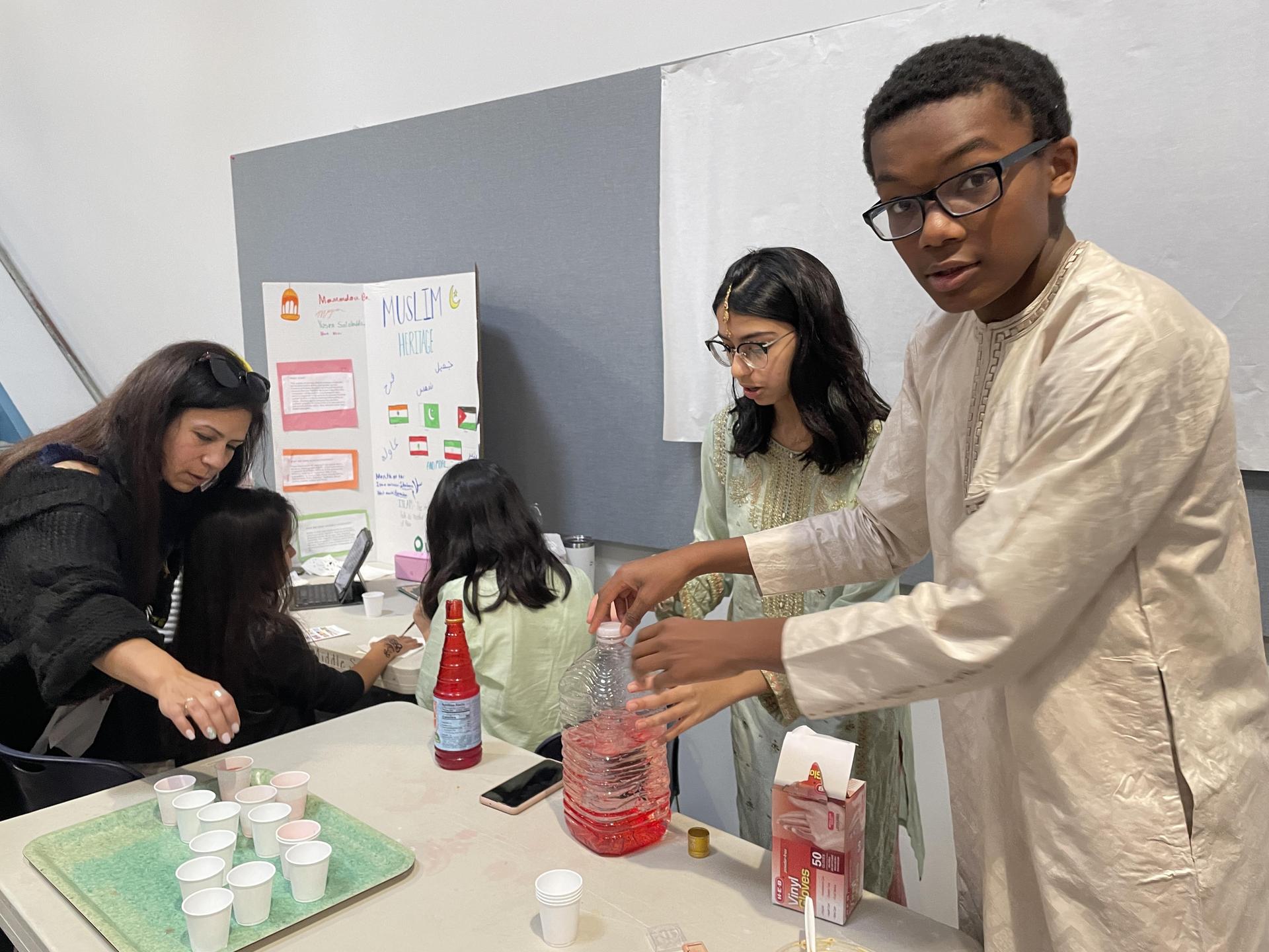 Students serve a red drink