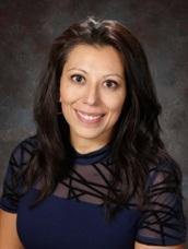 Portrait of a woman with dark hair in a black shirt, smiling at the camera.