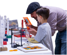 An adult leans over with a child to view a science experiment