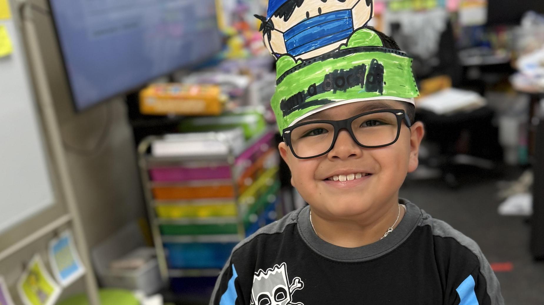 Seminole Primary student smiling while cutting out images
