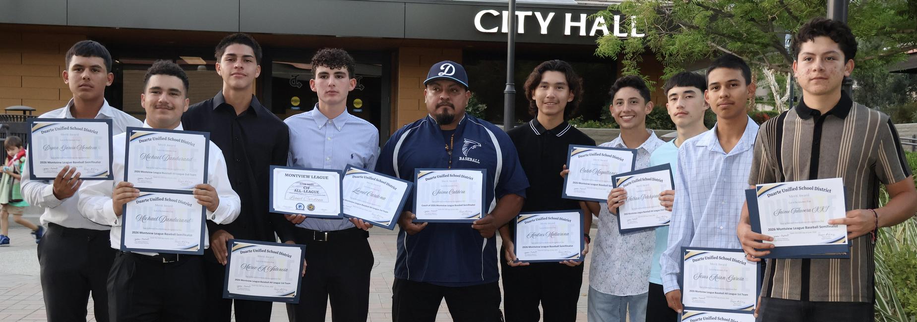A group of students proudly displaying their certificates at a ceremony.