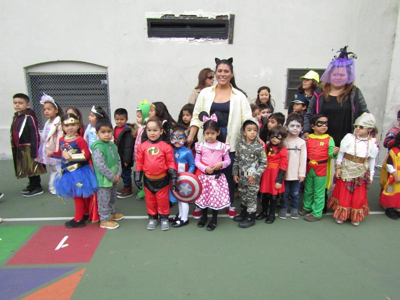 Kitty Cat teacher standing by her pre-k classroom in their costumes