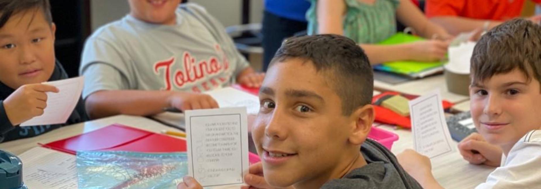 student holding up a task card