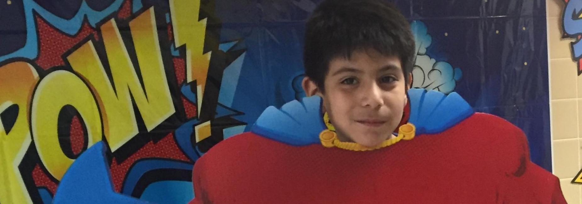 Estudiante posando con recorte de superhéroe