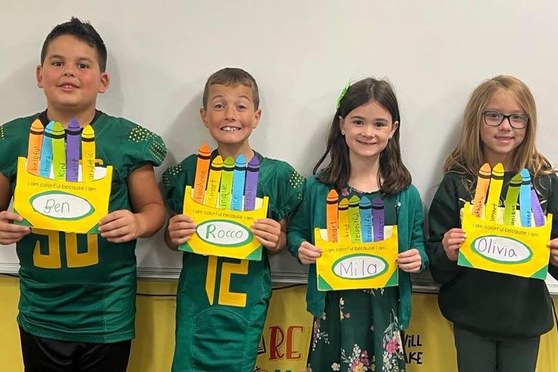 Ben Thoma, Rocco Yezovich, Mila Karls, and Olivia Oberkofler hold their crayon creations