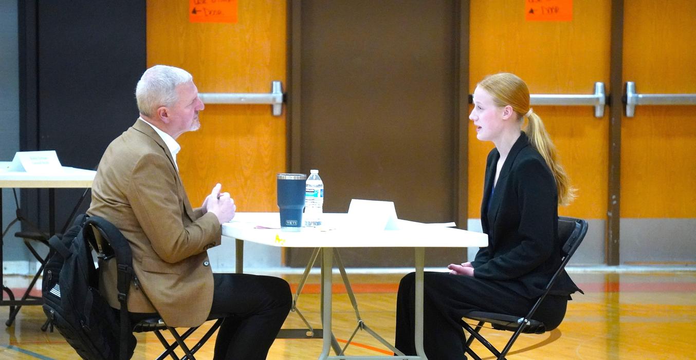 A senior goes through a mock interview process with a community volunteer.