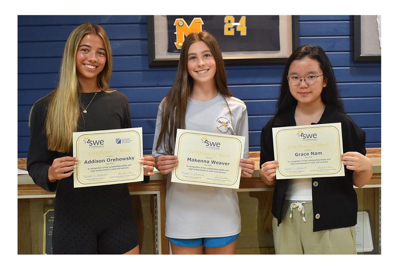 Three girls holding certificates.