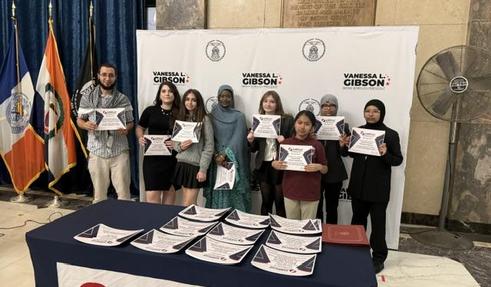 Students and a teacher standing with their certificates