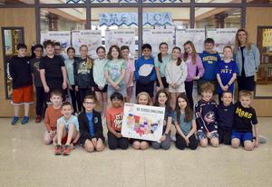 Large group of students posing with a map in front of '50 States Challenge' displays.