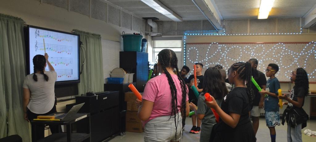 Students using musical tubes in music class