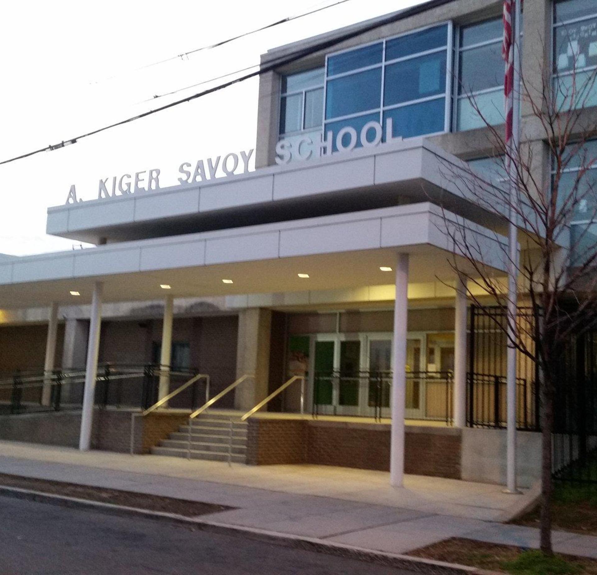 Exterior view of A. Kiger Savoy School with entrance and signage.