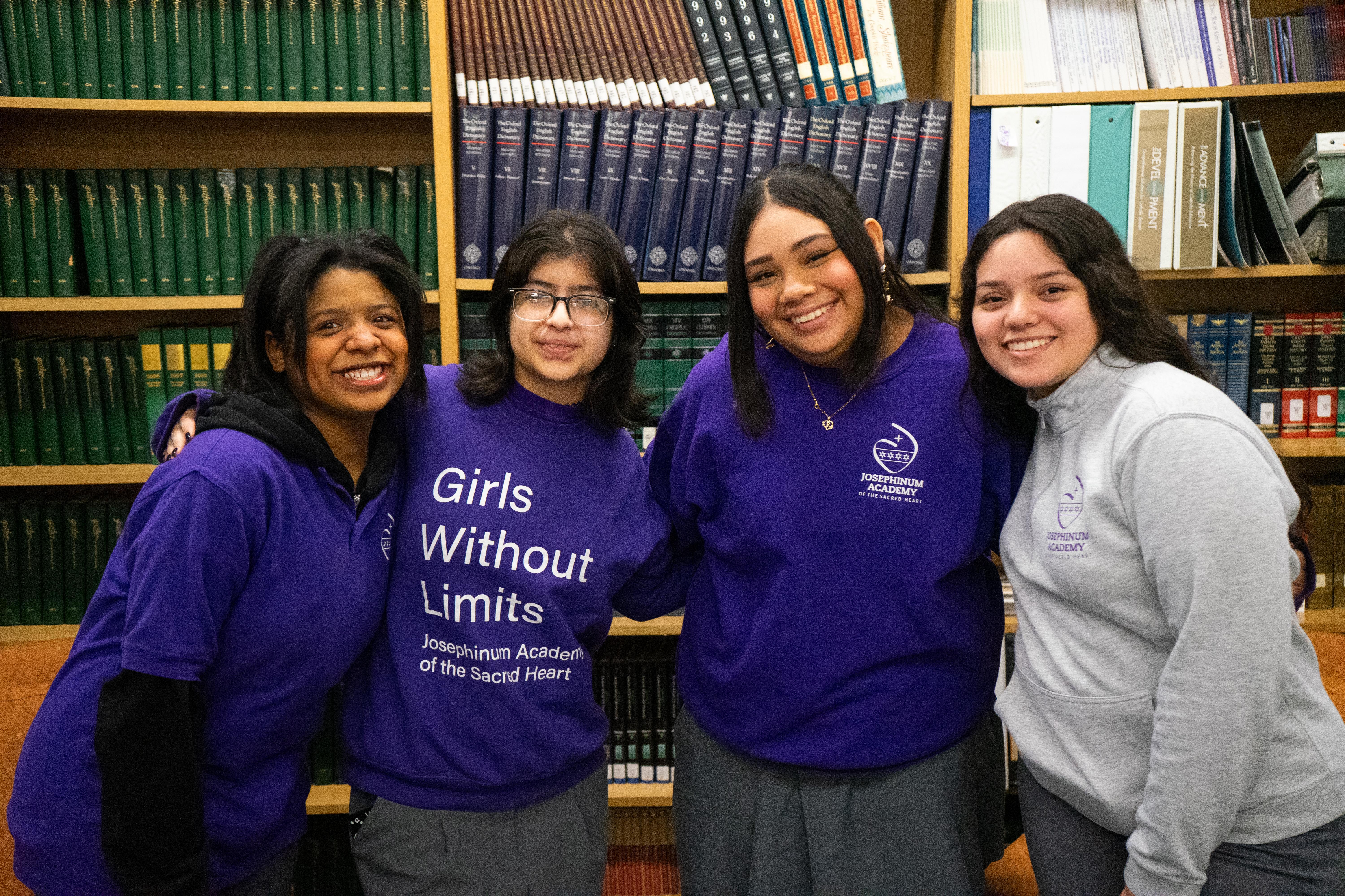 Students cheerfully standing in front of library books
