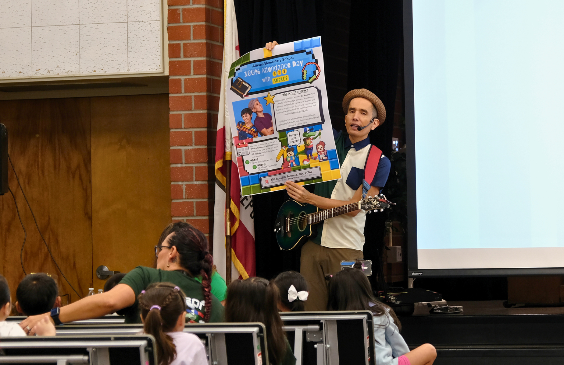 Andres 123 Visits Allison Elementary School - image of Andres playing guitar, and the students are singing along