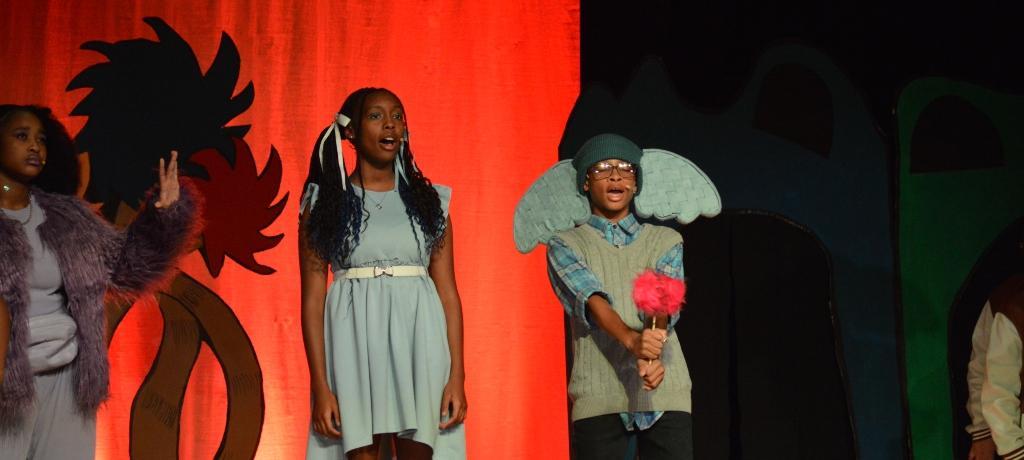 two students on stage singing