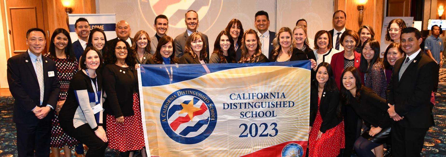 Group of people celebrating with a banner for California Distinguished School 2023.