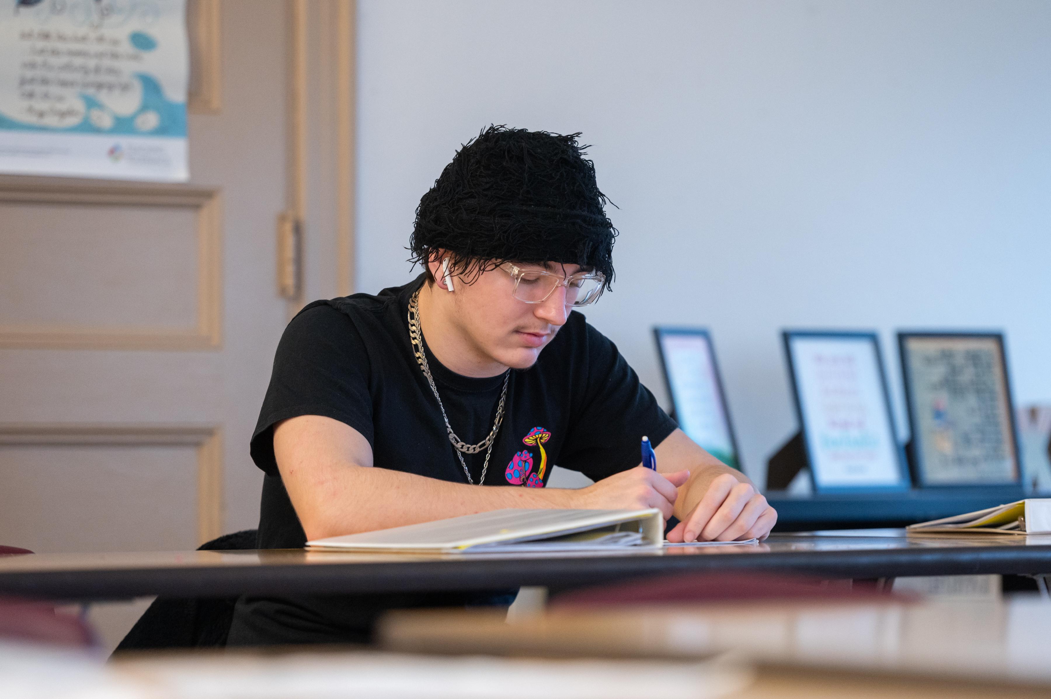 student writing at a desk