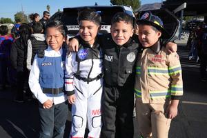 four students dressed up like SWAT, astronauts, law enforcement and fire fighter