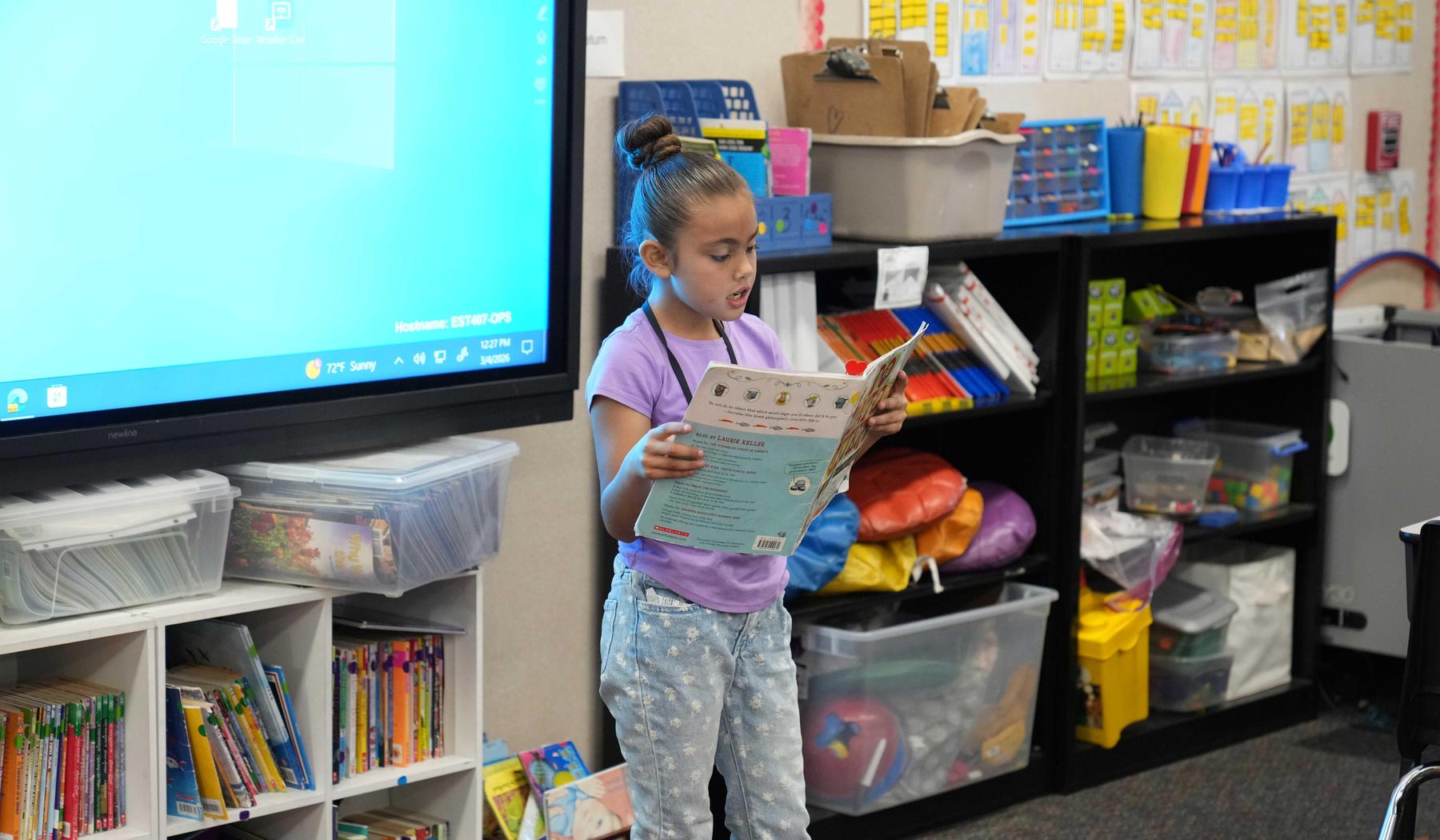 Girl reading to her class