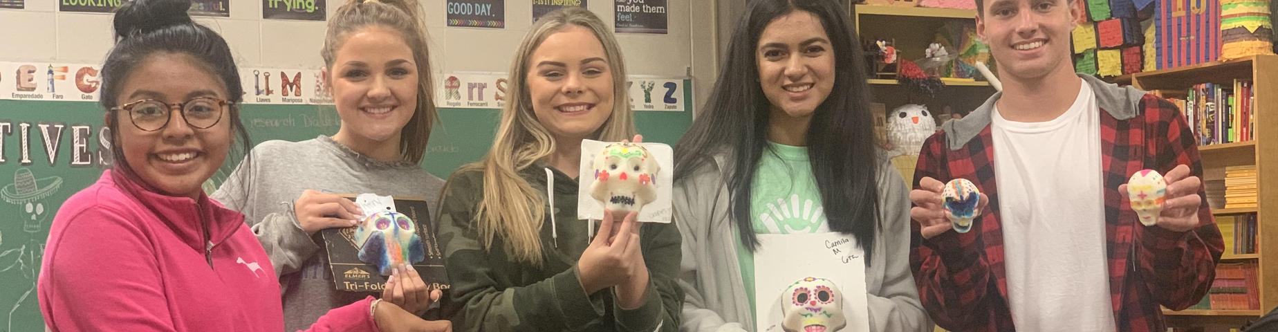 Students from Mayfield High School show off their sugar skulls, created in Mrs. Godinez's class for Dia de los Muertos!