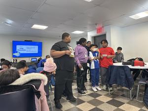 Students reading aloud their research to the seniors