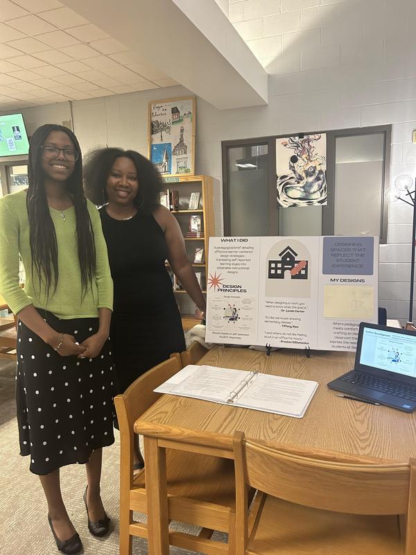 Smiling students stand with school projects