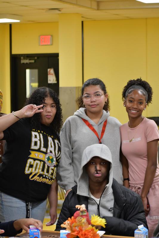 Students sitting and standing around a table
