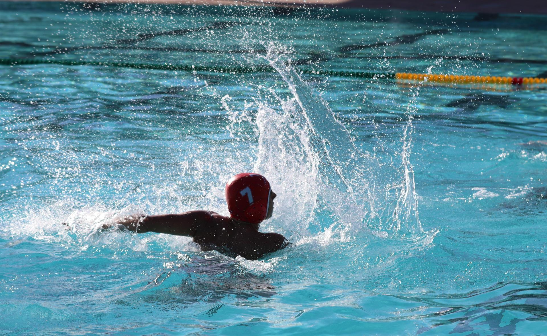 boys water polo players in action against hoover