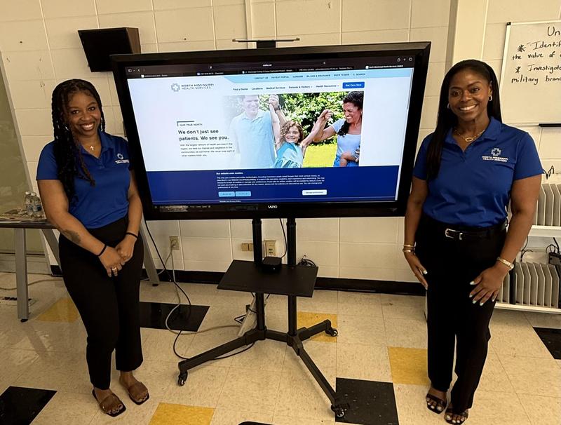 Anna and Rhonda standing by powerpoint screen