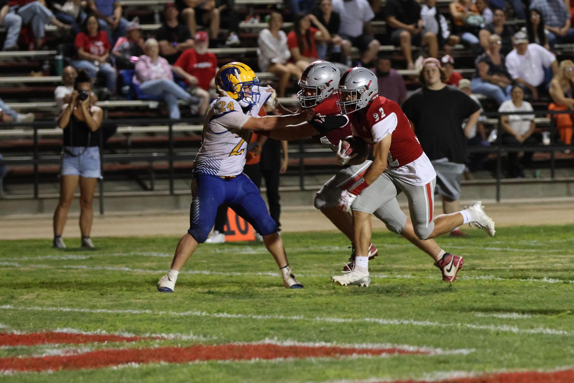 Varsity football players in action against Parlier 88