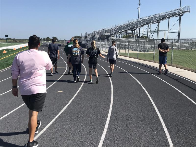 Student walk the track, getting exercise outdoors while socially distanced.